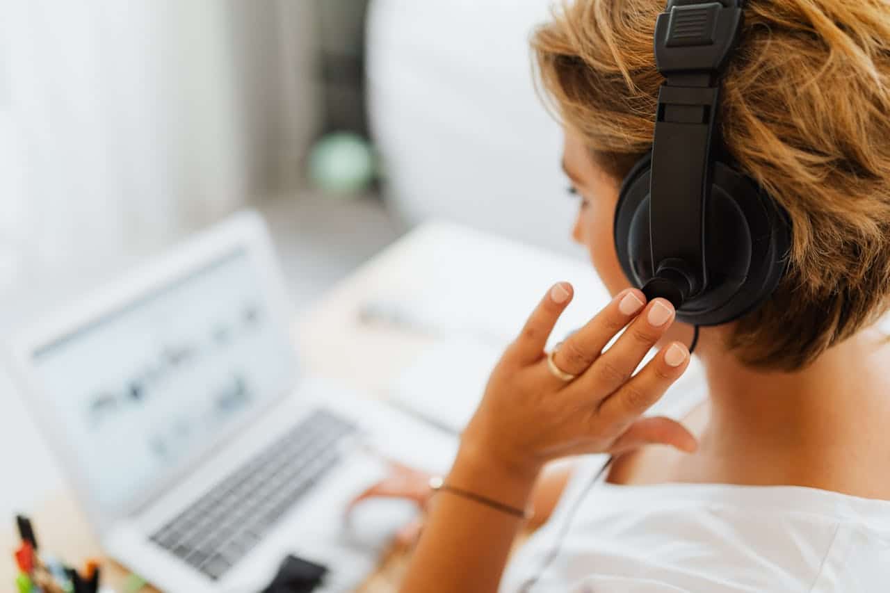 Operatrice di call center con cuffie mentre lavora da remoto al computer, esempio di gestione omnicanale del servizio clienti.