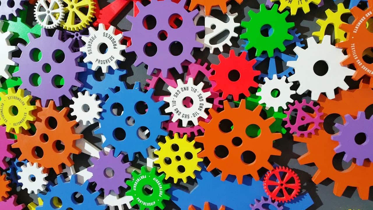 Ingranaggi colorati che simboleggiano l’automazione e l’ottimizzazione dei processi nei call center tramite machine learning e intelligenza artificiale.